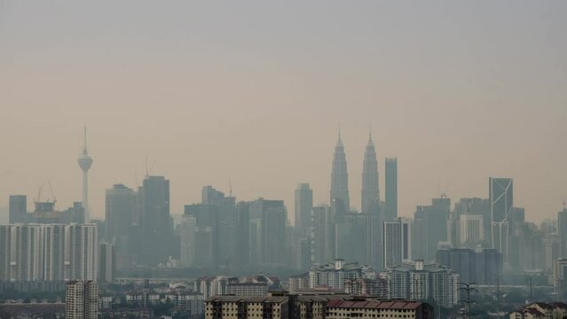 4k Time lapse of Kuala lumpur city center klcc with many highrise building skyscrapers in financial distict center area with snog smoke air pollution pm2.5 in the air