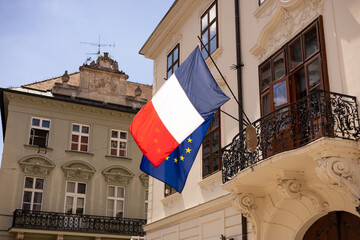 French and European Union flags fluttering together in the wind. Flags of France and the European Union on the building