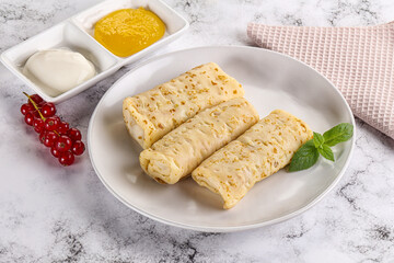 Homemade stuffed pancakes with honey and cream sour