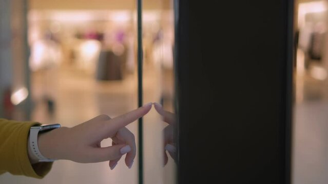 Girl using a touch terminal in a shopping mall. The concept of people and technologies. Online Router