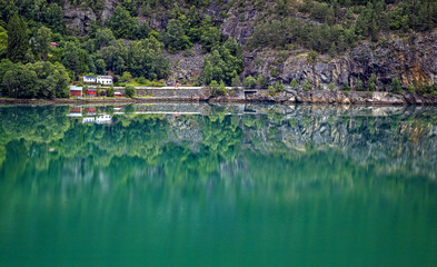 Fototapeta na wymiar Red and white house sit on the waters edge near Skjolden, Norway