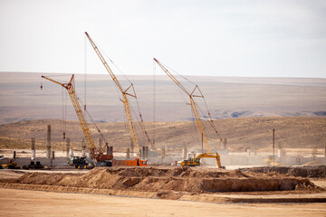Lifting cranes and other equipment at a construction site. A group of lifting platforms for...