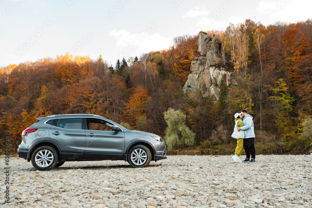 Wall mural couple travelers stop at rocky river beach