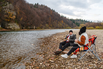 happy couple having picnic at river beach