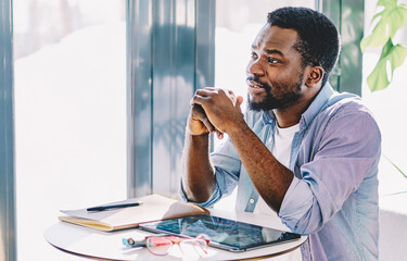 Fototapeta premium Thoughtful freelancer with tablet at workplace