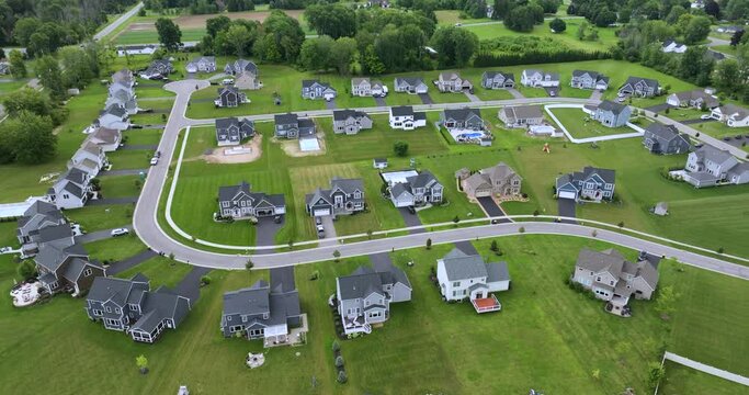 Upscale suburban homes with large backyards and green grassy lawns in summer season. Private residential houses in rural suburban sprawl area in Rochester, New York