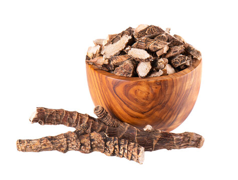 Calamus root in wooden bowl, isolated on white background. Sweet flag, sway or muskrat root. Dry root of Acorus calamus.