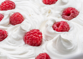 Fresh raspberries in the yoghurt or cream. Top view.