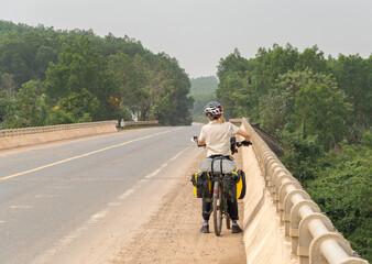 Nomadic woman travels on her bicycle loaded with bags