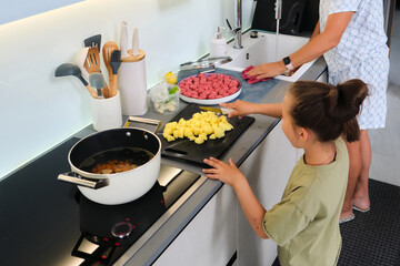 Grandmother and granddaughter are preparing soup.