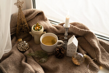 Christmas composition. Hot tea, candles, Christmas golden balls and decorations. Christmas holiday mood. Winter concept.
