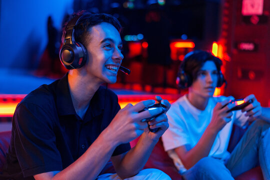 Two teen friends are playing a game console