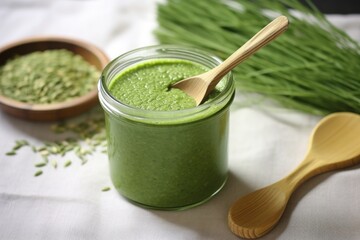 green flaxseed smoothie with a bamboo spoon on a tablecloth