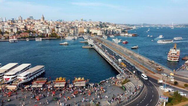 Drone, aerial view of Galata Bridge overlooking Bosphorus and city. Movement of cars, boats and ships. Istanbul, Turkey. Automobile traffic, fishermen fishing from bridge. Area, tourist place.