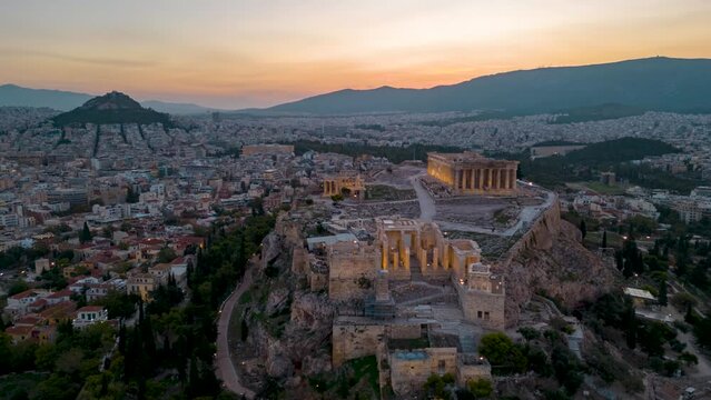 Aerial hyper time lapse view of the illuminated Parthenon and Athena Nike Temple at the Acropolis of Athens, Greece, during golden sunrise