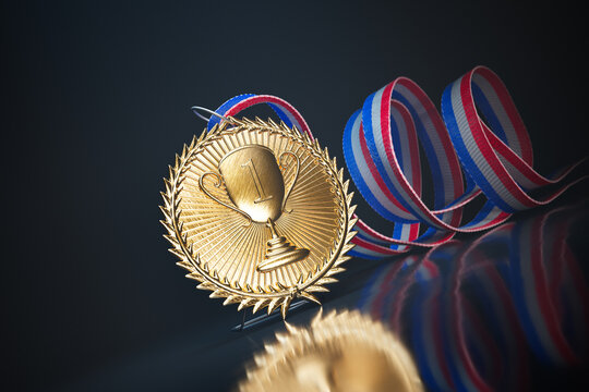Gold medal with colorful ribbon on a black reflective surface for the top winner