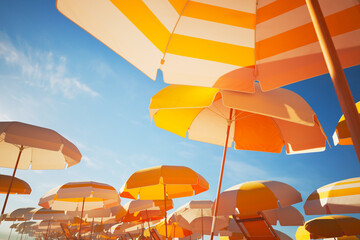 Vacations and travel concept. Yellow umbrellas or parasols against blue sky © Dabarti