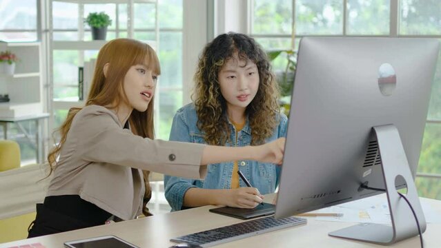 Collaboration of graphic design business people with computer in an office company. Two corporate women in creative marketing team working on project management , high five after a job is completed