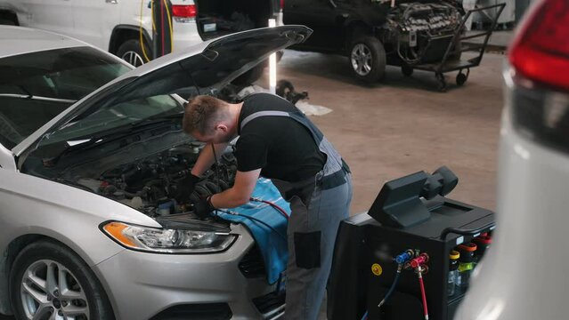 Car maintenance service. The mechanic makes diagnostics of the engine compartment using