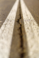 Crack in the middle of two white lines on the road