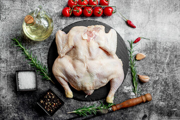 whole raw chicken on a stone background 