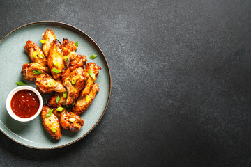 Chicken wings in bbq sauce grilled meat. Restaurant dish. Top view on black stone table.