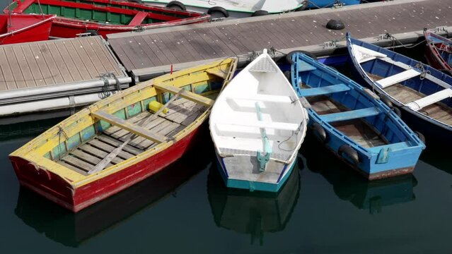 Colorful wooden tour boats in spanish sea port on tranquil rippled water close up