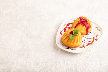 Obraz na płótnie Canvas Semolina cheesecake with strawberry jam on gray concrete, side view, copy space.