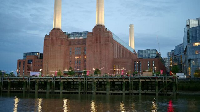 View of Battersea Power Station from a floating boat on the Thames River at sunset in London, United Kingdom