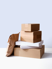 Set of cardboard parcels and paper envelopes on neutral background in studio