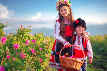 Bulgarian Rose Damascena field, Roses valley Kazanlak, Bulgaria. Boy and girl in ethnic folklore...