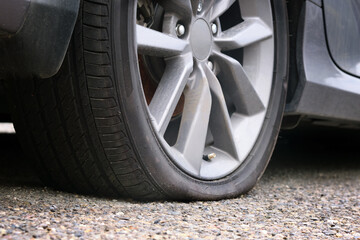 Close-up of a flat tire of a passenger car on the road.