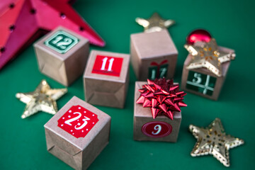 Artisanal Advent calendar: kraft paper cubes with numbers against a vibrant green backdrop. Embrace...
