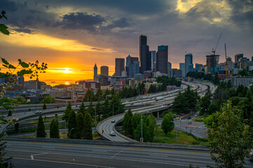 Dramatic sunset over the Seattle downtown skyline, with traffic on the I-5 and I-90 freeway interchange, viewed from Dr. Jose Rizal Bridge.