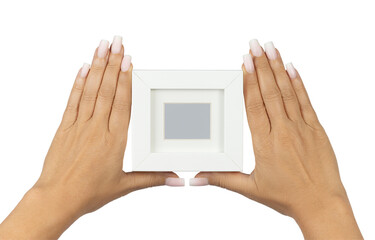 Adult female hands with long square ombre manicured nails, holding up an empty photoframe with borders. Isolated on a white background. © Nynke