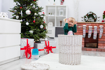 A little girl sits in a wicker basket in the middle of the room