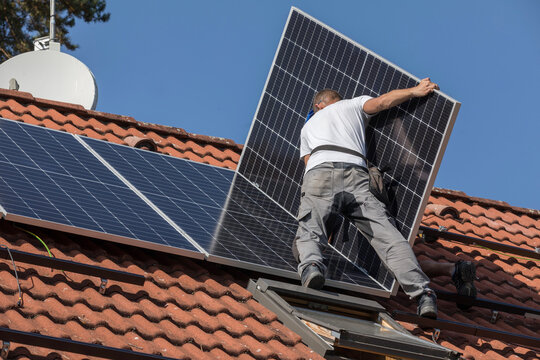 Workers prepare the roof for the installation of solar panels. Two men on the roof of a family house. Photovoltaic installation