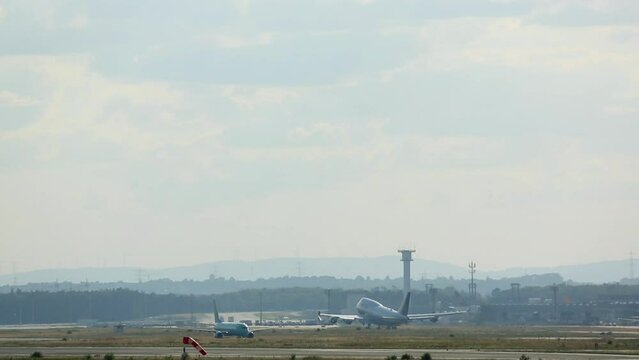 Heavy four-engine double-deck aircraft flies away. Huge plane jumbo jet with an unrecognizable livery taking off and climbing, backlit