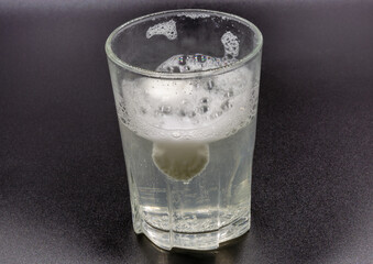 Dissolving instant effervescent tablets in a glass of water closeup
