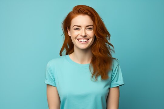 Smiling Portrait of a Beautiful Fictional Young Woman Wearing Blank Cyan T-Shirt. Isolated on a Plain Blue Colored Background. Generative AI. 