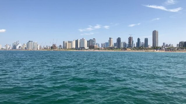 Panorama of Tel Aviv, skyscrapers. View from the sea, sail boat trip. A modern metropolis in the Middle East.