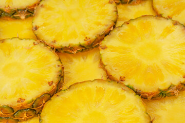 Pineapple juicy yellow slices as a background.