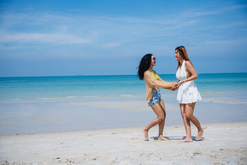 Fototapeta na wymiar Happy girls enjoying freedom and walking on the beach., Summer holidays and vacation concept..
