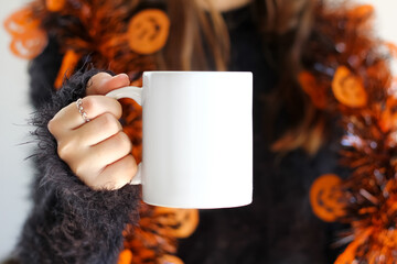 Girl is holding white 11 oz mug in hands with orange black sweater.  Halloween blank ceramic cup	
