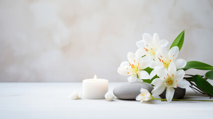 A tranquil spa still life with a white flower arrangement, two candles, and massage stones on a white background.
