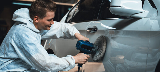 Automotive repair shop, concept of car detailing and polishing by professional car service worker...