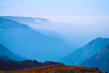 Mountain gorge in fog at sunset. Shooting with a long lens. Copy space