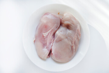 Pieces of chicken fillet in a white cup. Fresh chicken meat in chunks.