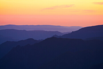 Picturesque golden pink sunset in the mountains. Shooting on a long lens. Copy space.