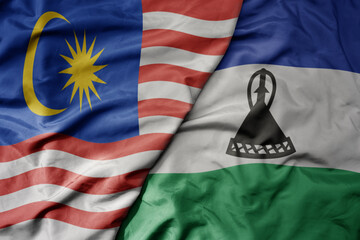 big waving realistic national colorful flag of malaysia and national flag of lesotho